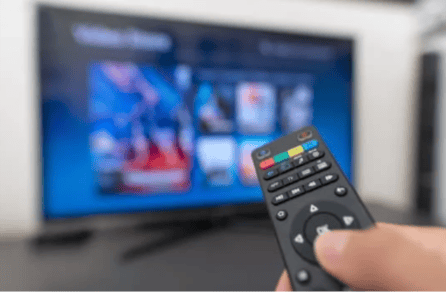 A hand holding a remote control in front of a television
AI-generated content may be incorrect.