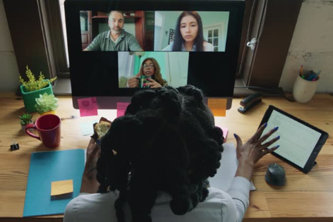 A person sitting at a desk with a group of people on their lap

Description automatically generated